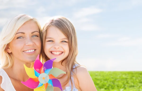 Mãe feliz e menina com brinquedo pinwheel — Fotografia de Stock