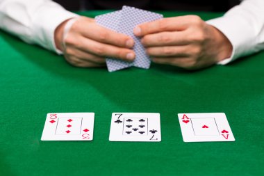 poker player holding playing cards at casino table clipart