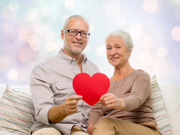Feliz pareja de ancianos con forma de corazón rojo — Foto de Stock