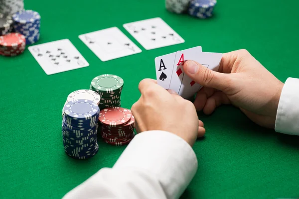 Pokerový hráč s karty a žetony v kasinu — Stock fotografie