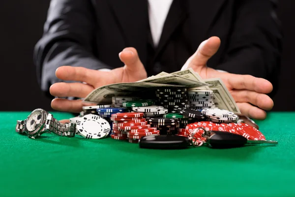 Poker player with chips and money at casino table — Stock Photo, Image