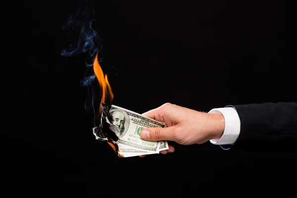燃焼ドルのお金を持っている男性の手のクローズ アップ — ストック写真