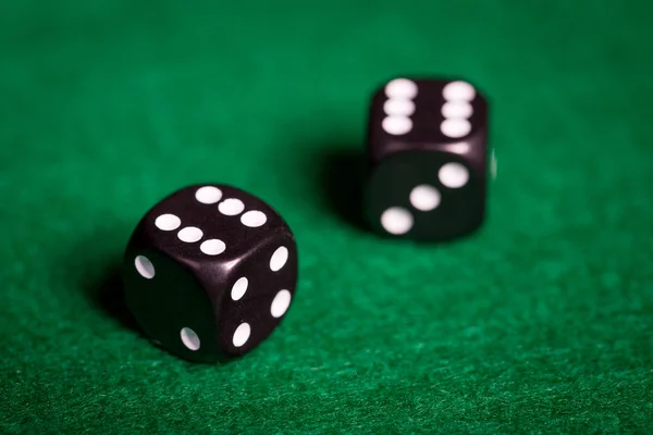 Close up of black dice on green casino table — Stock Photo, Image