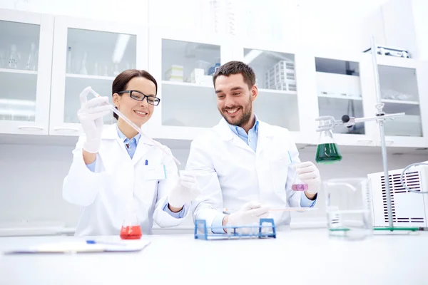 Jovens cientistas que fazem testes ou pesquisas em laboratório — Fotografia de Stock