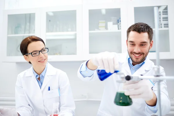 Jóvenes científicos haciendo pruebas o investigaciones en laboratorio —  Fotos de Stock