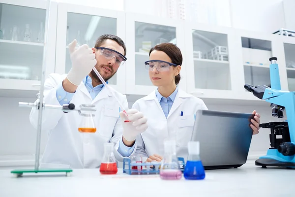 Jóvenes científicos haciendo pruebas o investigaciones en laboratorio —  Fotos de Stock