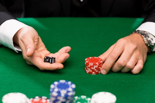 Pokerspeler met dobbelstenen en chips bij casino Stockfoto