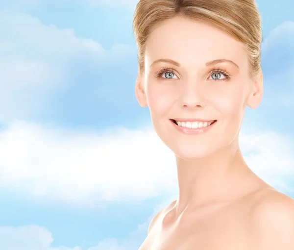 Vicino di donna sorridente su sfondo cielo blu — Foto Stock