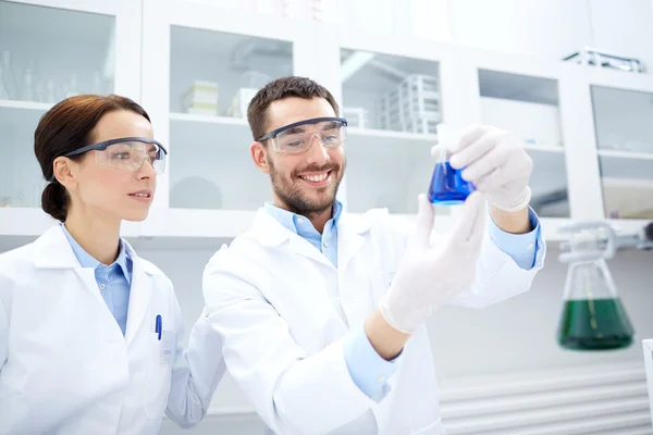 Jóvenes científicos haciendo pruebas o investigaciones en laboratorio —  Fotos de Stock