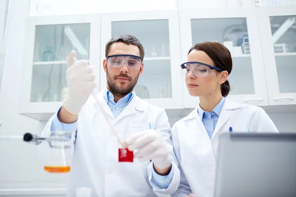 Jovens cientistas que fazem testes ou pesquisas em laboratório — Fotografia de Stock