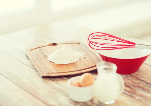 Jugful of milk, eggs in a bowl and flour — Stock Photo, Image