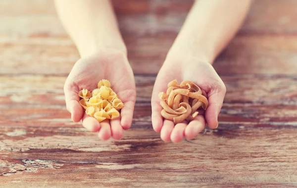 Vrouwelijke handen met verschillende pasta variaties — Stockfoto