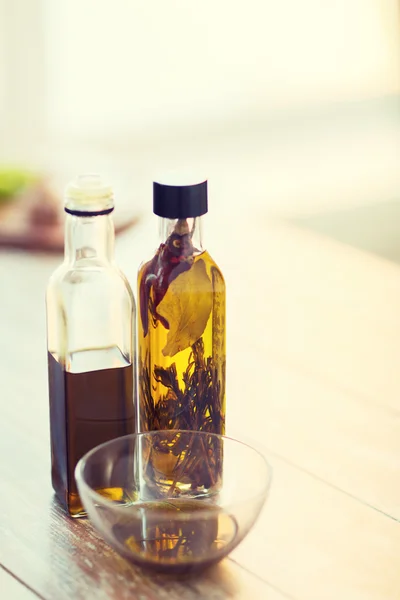 Primer plano de dos botellas de aceite de oliva y un tazón de aceite — Foto de Stock