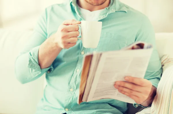 Close up of man with magazine drinking from cup — Stock Photo, Image