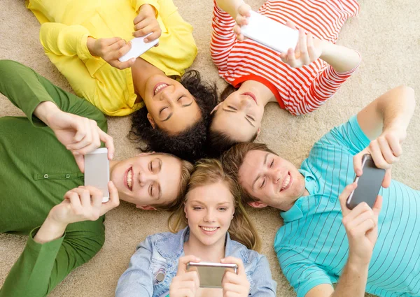 Groep lachende mensen liggen op de vloer — Stockfoto