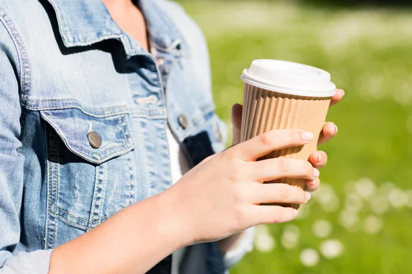 屋外のコーヒー カップを持つ若い女の子のクローズ アップ — ストック写真