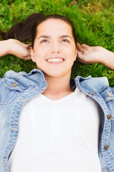 Sorrindo menina deitada na grama — Fotografia de Stock