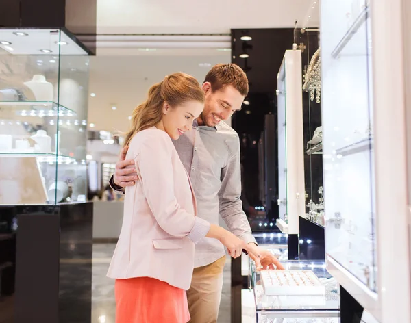 Feliz pareja eligiendo anillo de compromiso en el centro comercial —  Fotos de Stock