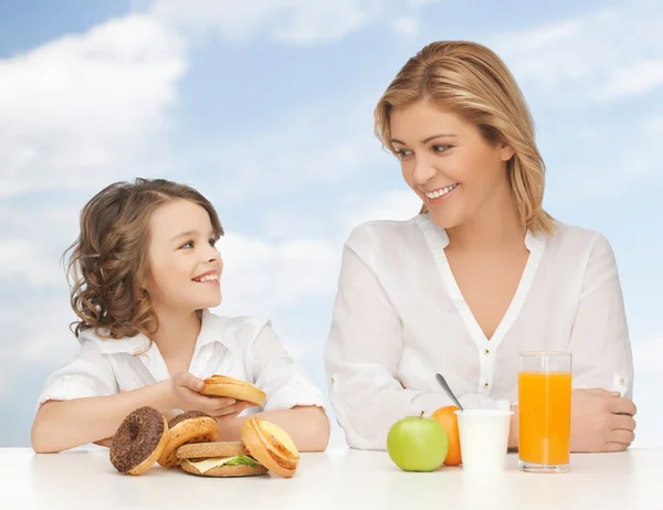 Mãe feliz e filha tomando café da manhã — Fotografia de Stock