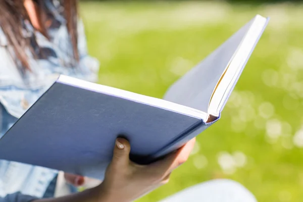 Primo piano di giovane ragazza con libro nel parco — Foto Stock