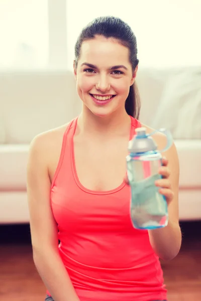 Chica sonriente con botella de agua después de hacer ejercicio —  Fotos de Stock