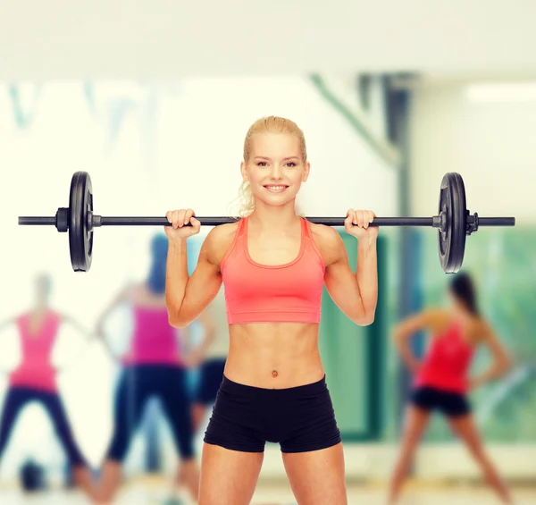 Lächelnde sportliche Frau beim Training mit der Langhantel — Stockfoto