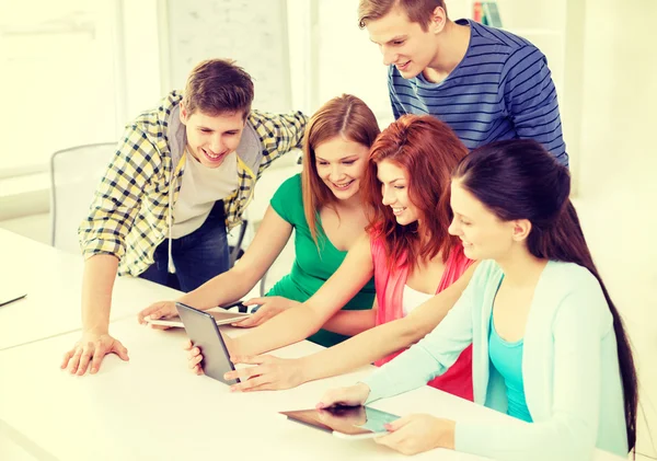 Lachende studenten met de tablet pc op school — Stockfoto