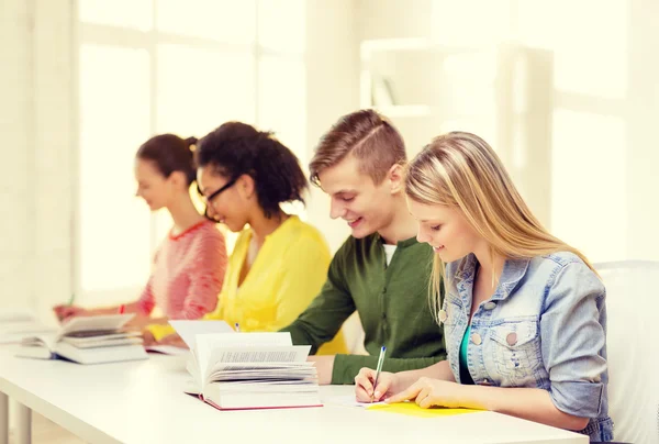 Studenter med läroböcker och böcker i skolan — Stockfoto