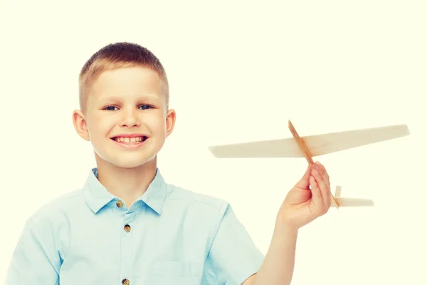 Küçük çocuk ahşap uçak model tutan gülümseyerek — Stok fotoğraf