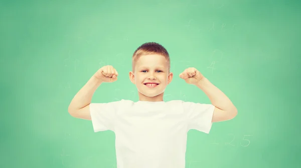 Glücklicher kleiner Junge im weißen T-Shirt, der den Bizeps beugt — Stockfoto