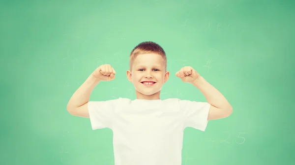 Счастливый маленький мальчик в белой футболке, сгибающий бицепсы Стоковая Картинка