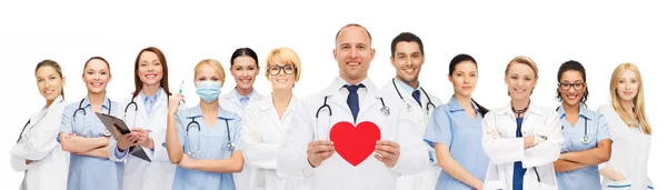 Grupo de médicos sorridentes com forma de coração vermelho — Fotografia de Stock