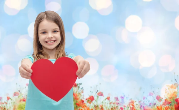 Chica sonriente con el corazón rojo fondo natural — Foto de Stock