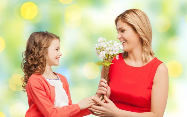 Happy little daughter giving flowers to her mother — Stock Photo, Image