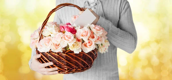 Man met mand vol met bloemen en briefkaart — Stockfoto