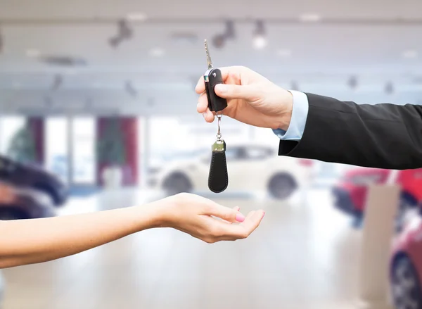Primer plano del cliente y del vendedor con la llave del coche — Foto de Stock