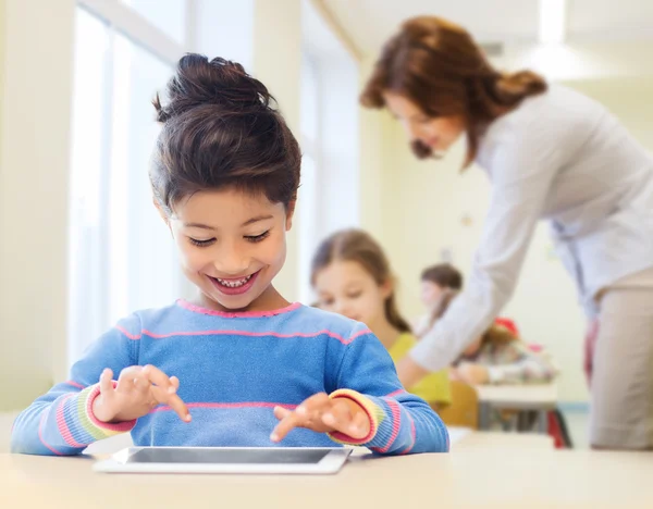 Petite écolière avec tablette pc sur salle de classe — Photo