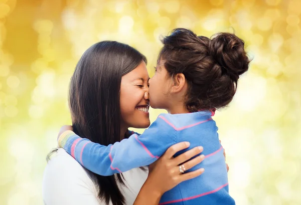 Feliz niña abrazando y besando a su madre — Foto de Stock