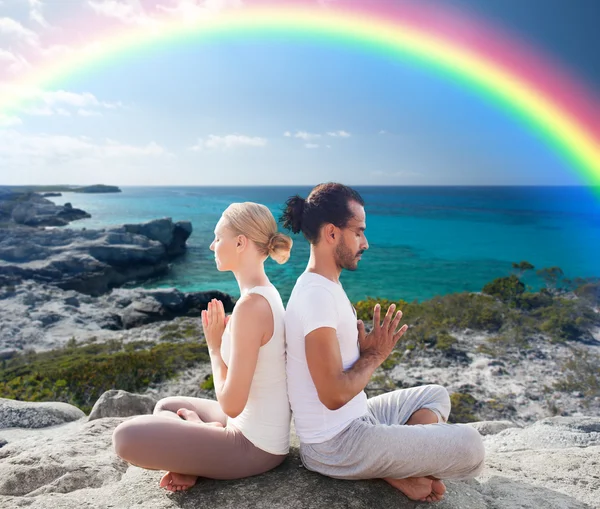 Glückliches Paar meditiert in Lotus-Pose am Strand — Stockfoto