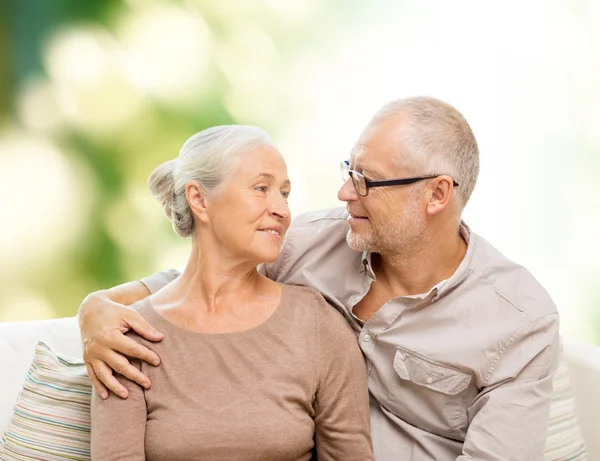 Gelukkige senior paar knuffelen op sofa thuis — Stockfoto