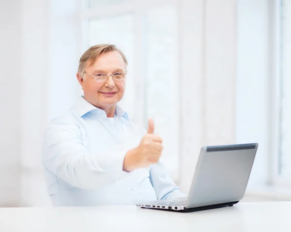 Viejo con computadora portátil mostrando los pulgares hacia arriba — Foto de Stock