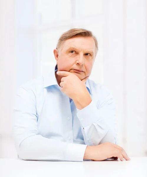 Stressed old man holding head at home — Stock Photo, Image