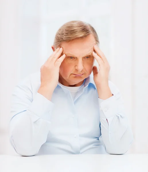 Stressato vecchio uomo tenendo testa a casa — Foto Stock