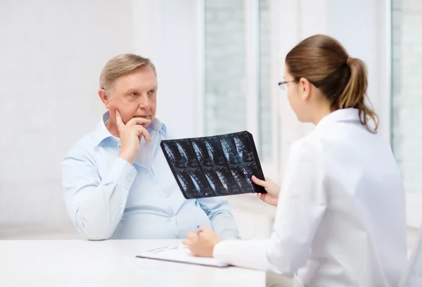 Doctora con anciano mirando rayos X — Foto de Stock