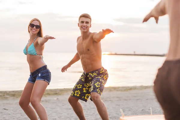 Lächelnde Freunde mit Sonnenbrille und Surfen am Strand — Stockfoto