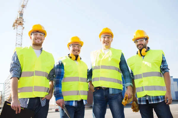 Grupp av leende byggare med TabletPC utomhus — Stockfoto