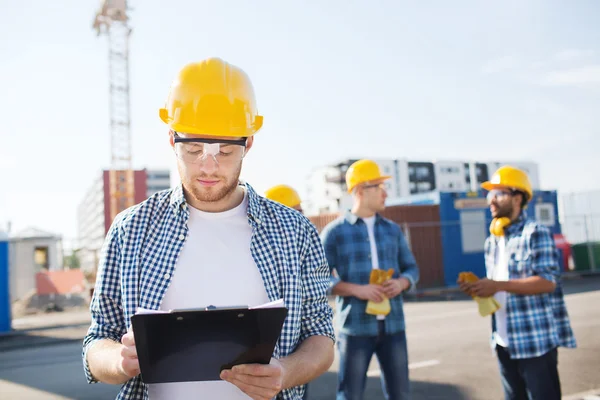 Ομάδα των οικοδόμων στο hardhats υπαίθρια — Φωτογραφία Αρχείου