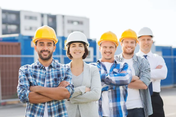 Groupe de constructeurs souriants en hardhats à l'extérieur — Photo