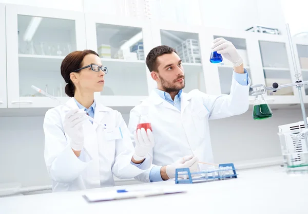 Jóvenes científicos haciendo pruebas o investigaciones en laboratorio —  Fotos de Stock