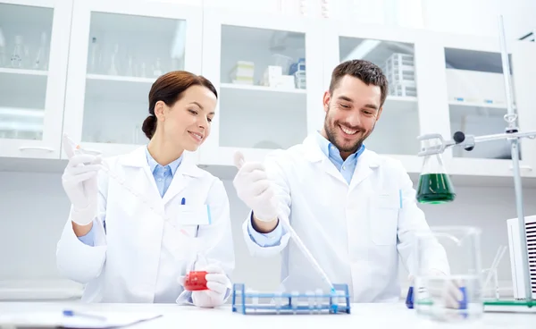 Jovens cientistas que fazem testes ou pesquisas em laboratório — Fotografia de Stock